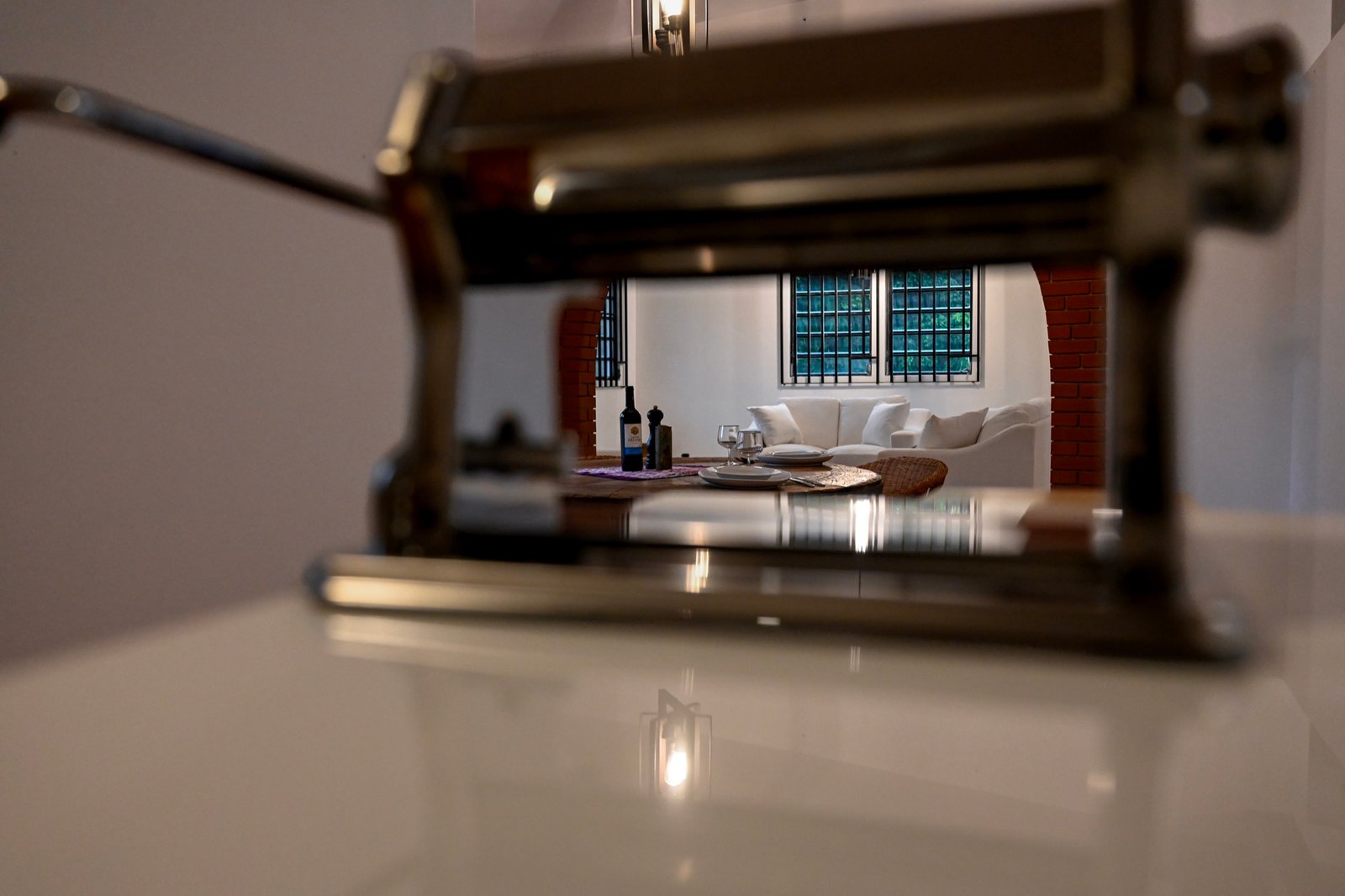 View through a manual pasta machine toward the dining table at the Hacienda