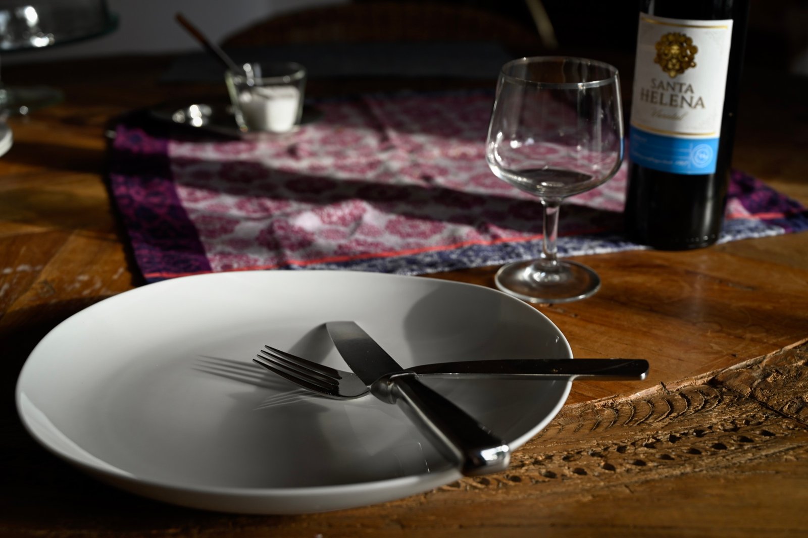 An empty white plate waiting on the table before the meal