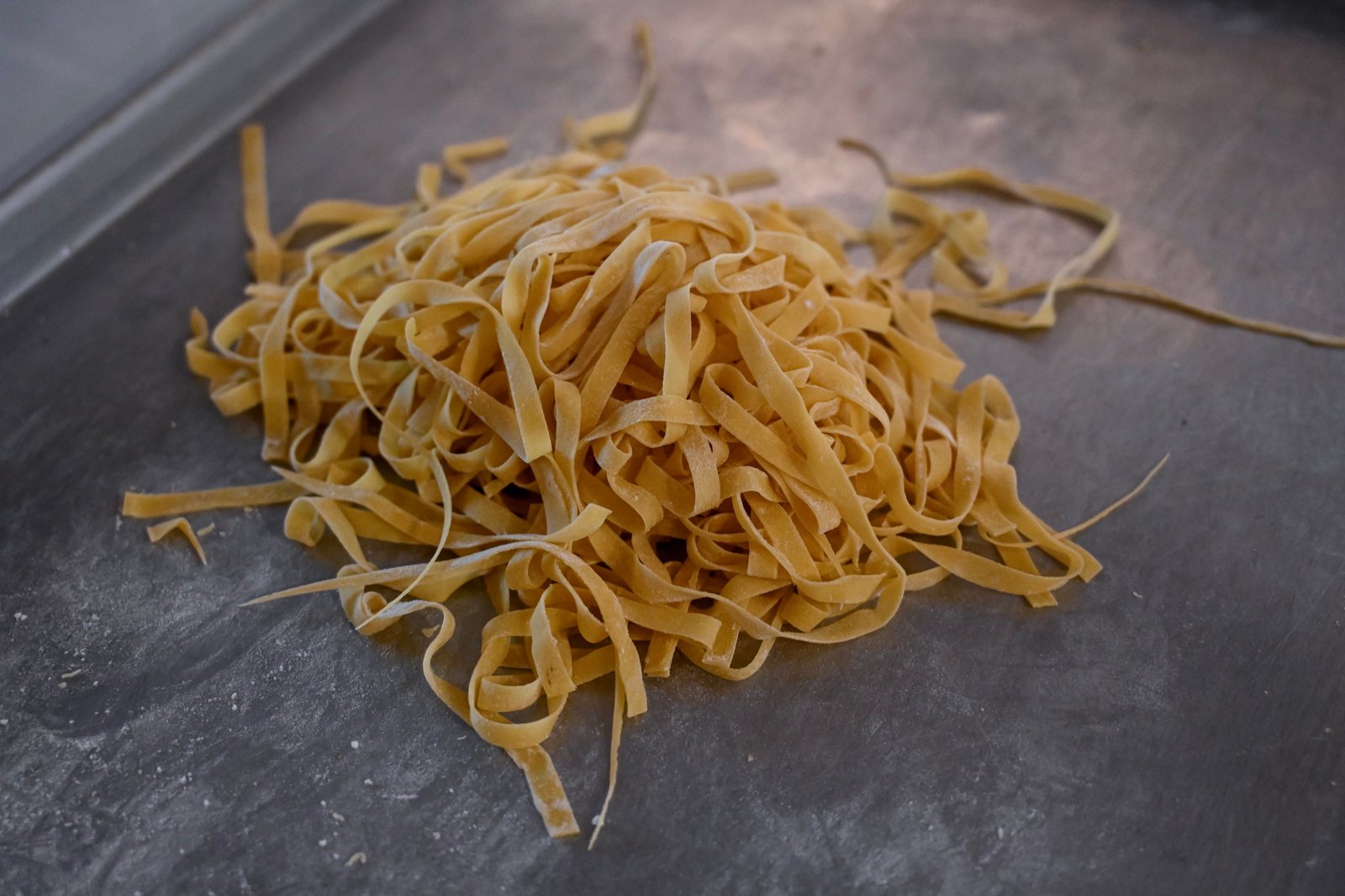 A loose nest of freshly cut handmade tagliatelle