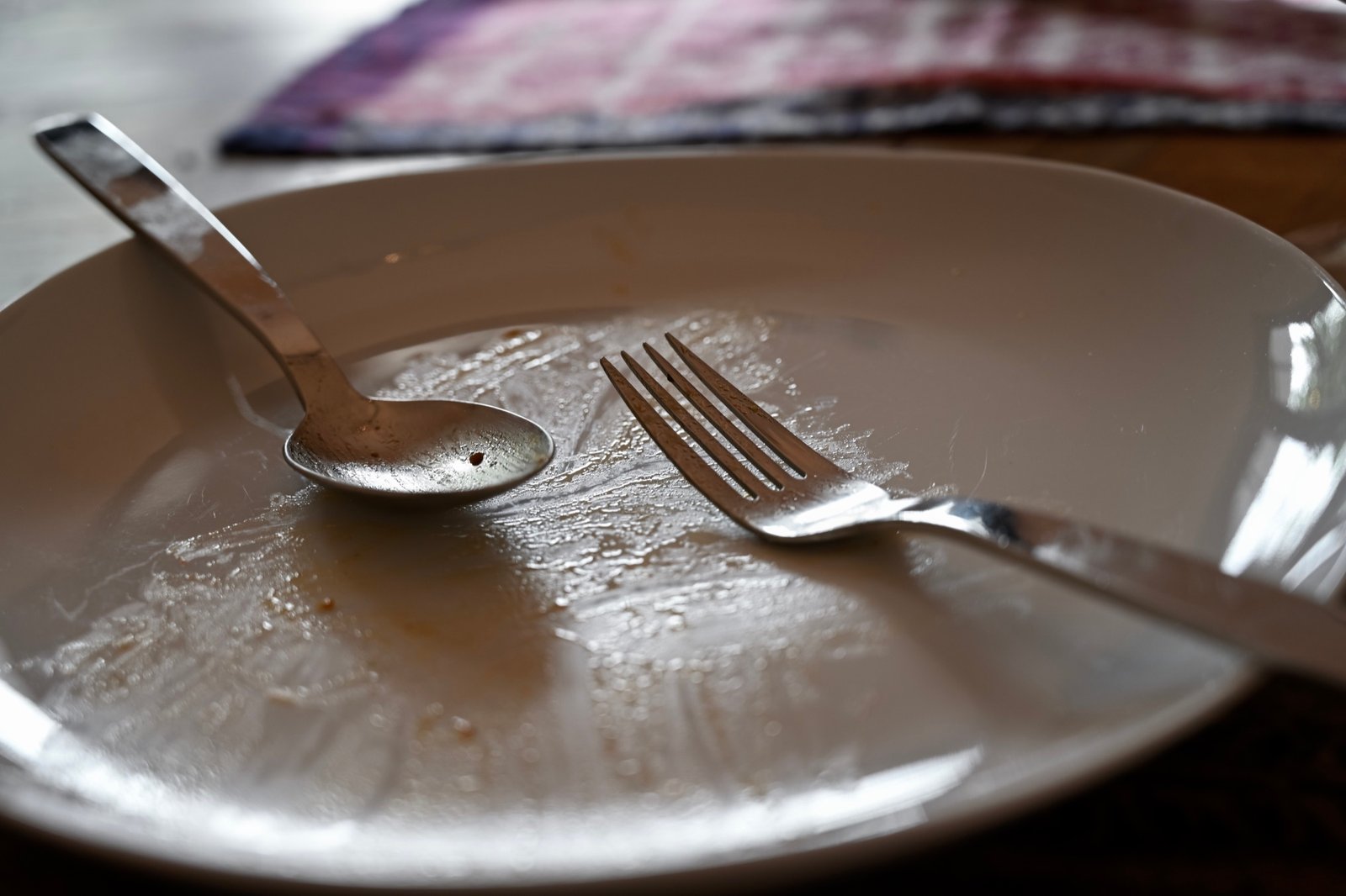 The empty plate, fork, and spoon after the fresh pasta meal